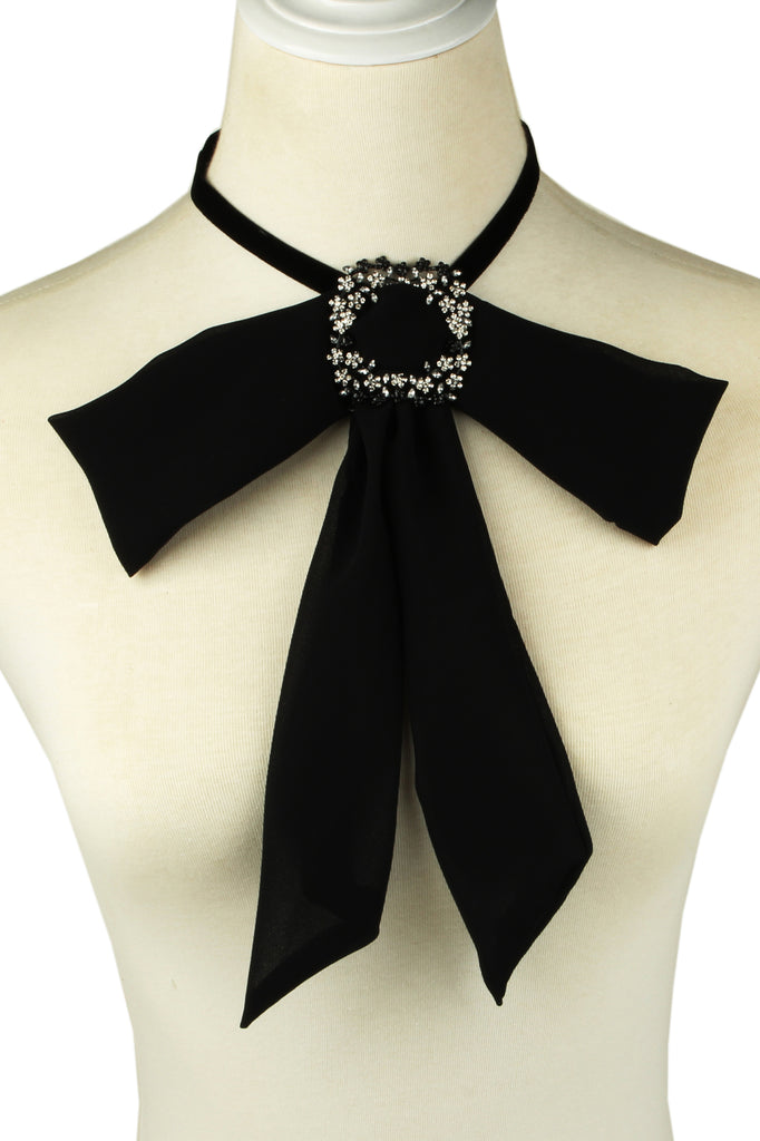 Black alloy bow tie necklace studded with glass crystals.